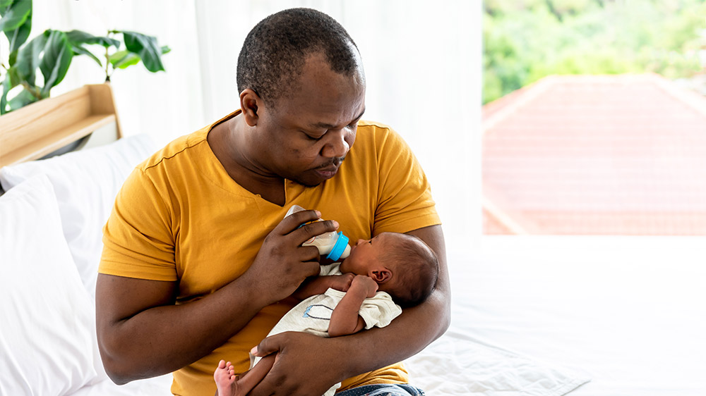 father feeding baby from bottle